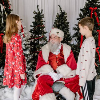 A girl and boy talk to Santa
